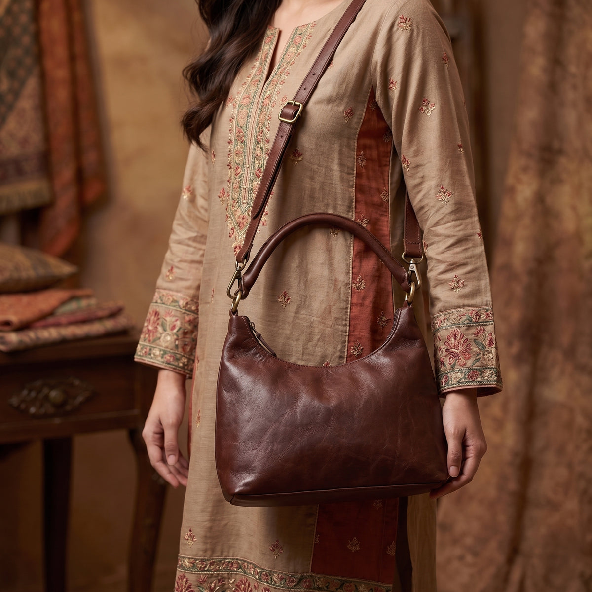 Close-up of a handcrafted brown leather handbag held by a model