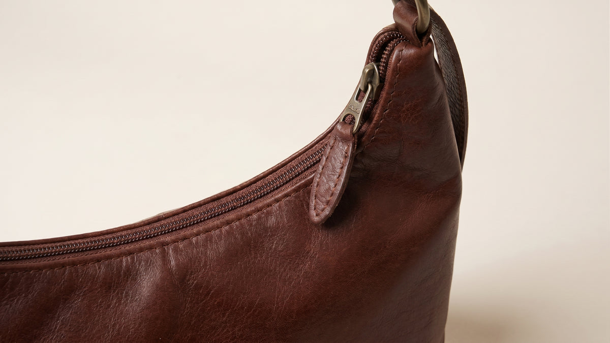 Close-up detail of zipper closure and solid brass hardware on Brut & Beau leather bag
