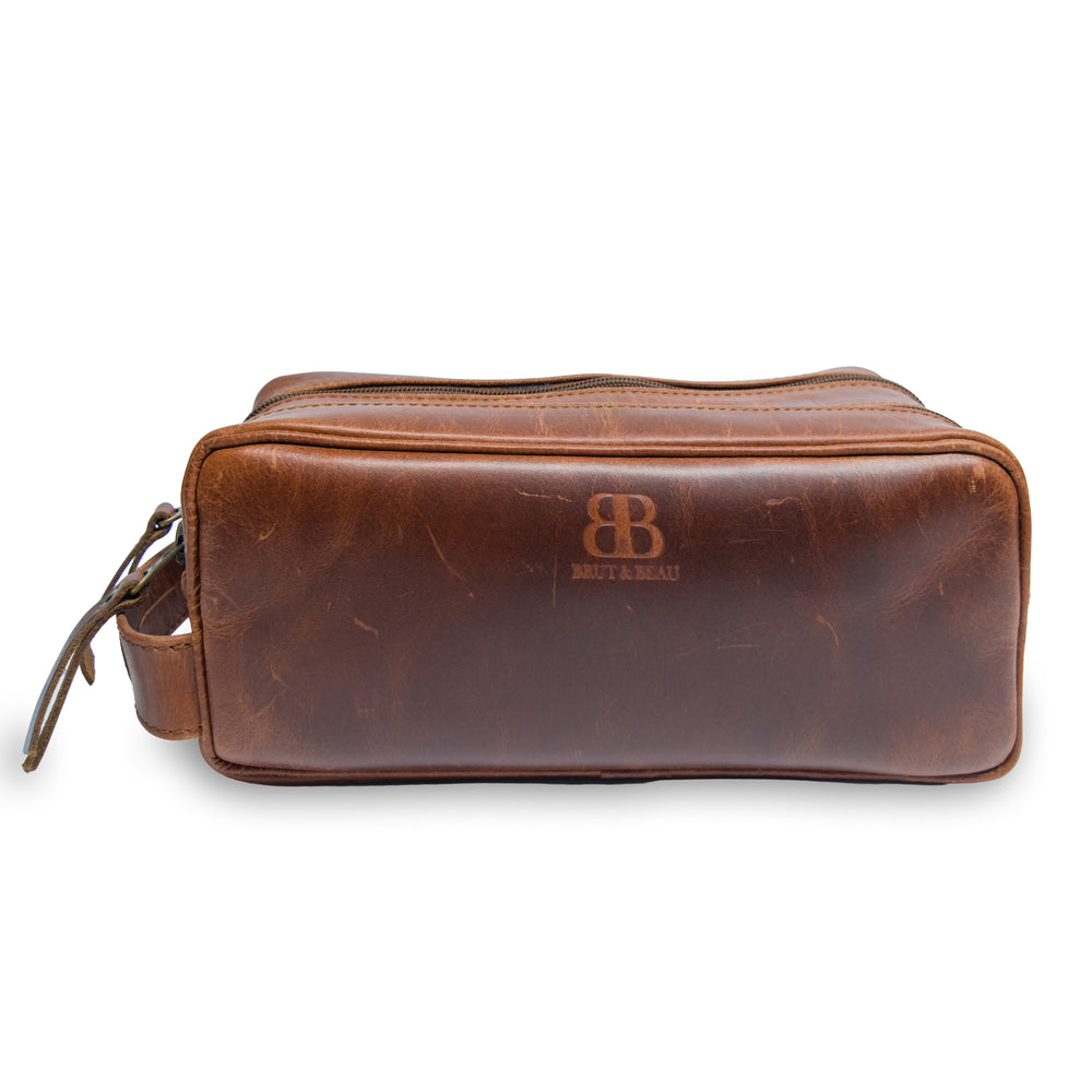 Front view of the Brut & Beau brown genuine leather shaving kit and toiletry bag featuring debossed logo branding